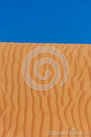 Contrast beautiful deep blue sky and orange rippled pattern sand dunes in the United Arab Emirates. Stock Photo