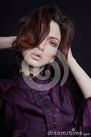 Contrast fashion Armenian woman portrait with big blue eyes on a dark background in a purple dress. Lovely gorgeous girl posing Stock Photo