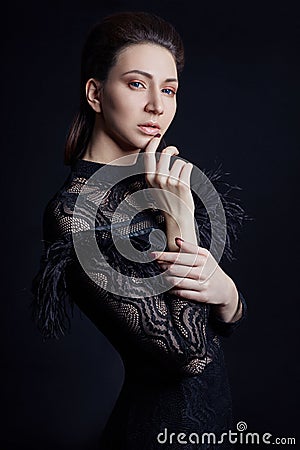 Contrast fashion woman portrait with big blue eyes on a dark background in a black dress. Lovely gorgeous girl posing in evening d Stock Photo