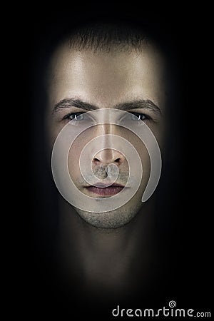 Contrasting male portrait on black background. Light and shadow on the man`s face. Stylish, brutal man, art photo. Silhouette face Stock Photo