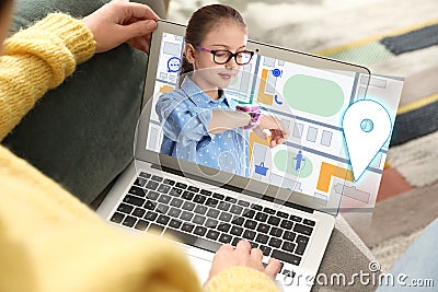 Control kid`s geolocation via smart watch. Woman using laptop indoors, closeup Stock Photo
