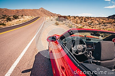 Convertible stopped on a shoulder in desert Stock Photo