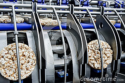 Conveyor automatic tape for the production of useful whole-grain extruder crispbread. Stock Photo