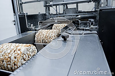 Conveyor automatic tape for the production of useful whole-grain extruder crispbread. packing organic multi-barley briquetted Stock Photo