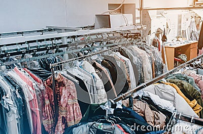 Conveyor with hangers of dry-cleaned clothes. Dry cleaning background Stock Photo