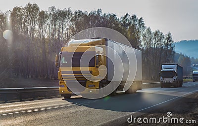 Convoy of trucks moves at dawn along the highway Stock Photo