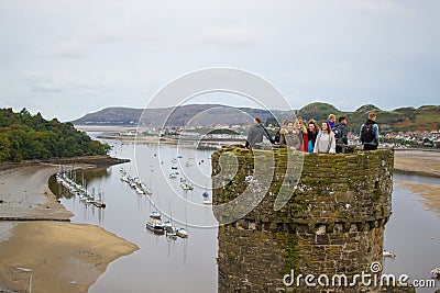 Conwy, Wales; 10/14/2018: Tourists on a tower of Conwy Castle, an ancient 13th Century stone built fortification in North Wales, Editorial Stock Photo