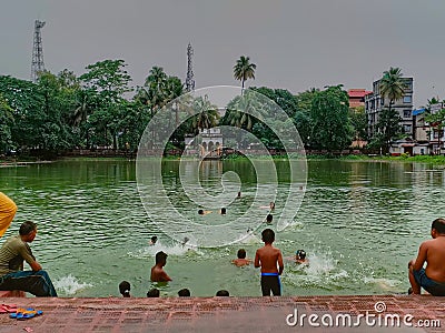 27.05.2022 coochbehar west bengal india, morning view of artificial lake with swimming people in west bengal Editorial Stock Photo