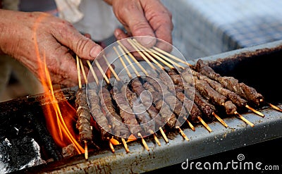 cook cooking of mutton kebabs called ARROSTICINI in italian lang Stock Photo