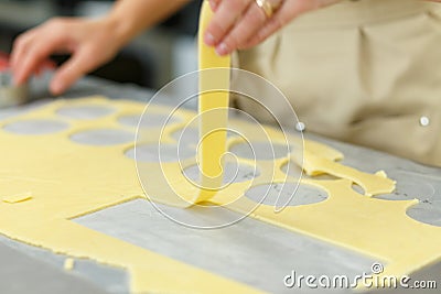 The cook hand raises a strip of dough Stock Photo