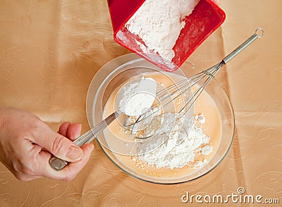 Cook hands adds flour into dish Stock Photo