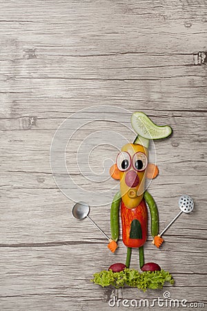 Chief made with vegetables and spoons on wooden background Stock Photo