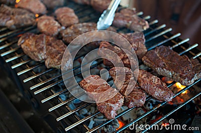 The cook prepares juicy steaks from marbled veal on grill Stock Photo