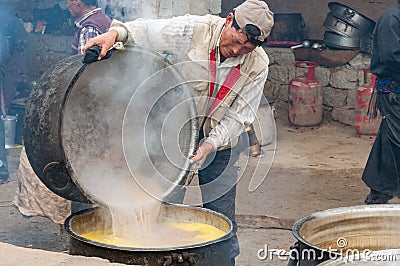 Cook preparing indian butter tea for buddhist ceremony in monastery Editorial Stock Photo
