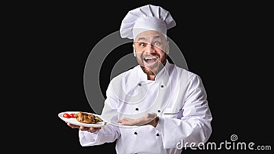 Cook Serving Chicken Dish Showing Plate On Black Background, Panorama Stock Photo