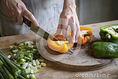 Cook slicing bell peppers on a cutting board Stock Photo