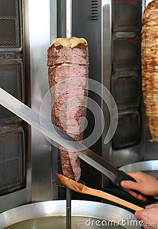 Cook Slicing Turkish Lamb Doner Kebab with a Sharp Sword like Knife Stock Photo