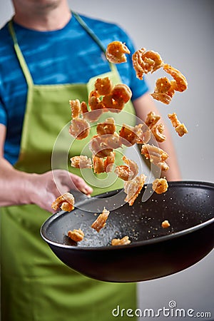 Cook throwing red prawns with a wok Stock Photo