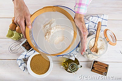 Cook woman sieving flour with her hands Stock Photo