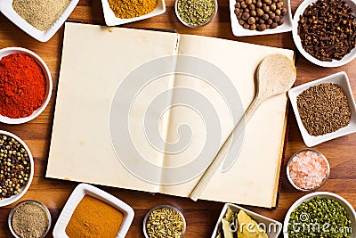 Cookbook and various spices and herbs. Stock Photo