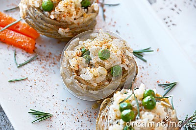 Cooked Artichokes with rice, green peas, carrot and olive oil. Stock Photo