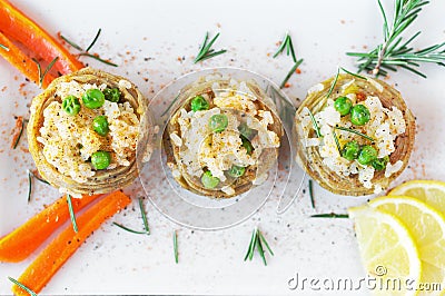 Cooked Artichokes with rice, green peas, carrot and olive oil. Stock Photo