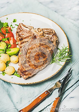 Cooked beef tbone steak with vegetables and fresh rosemary Stock Photo