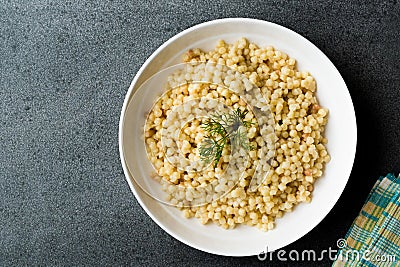 Cooked Couscous with Dill served in White Plate / Turkish Kuskus Stock Photo