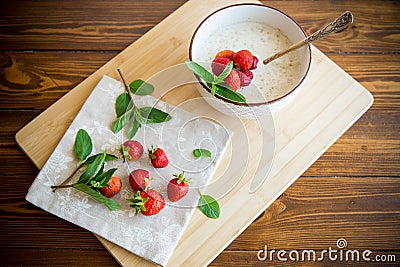 cooked diet oatmeal in a bowl with fresh ripe strawberries Stock Photo