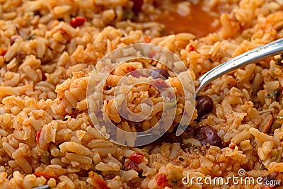 Cooked Mexican rice and beans in a skillet with a heaping spoonful on the food Stock Photo
