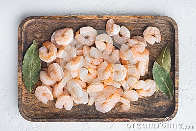 Cooked peeled prawns, shrimps, on wooden tray, on white stone background, top view flat lay Stock Photo