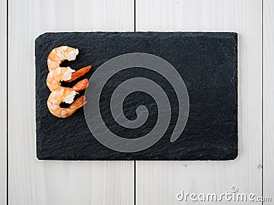 Cooked peeled shrimps on slate board Stock Photo