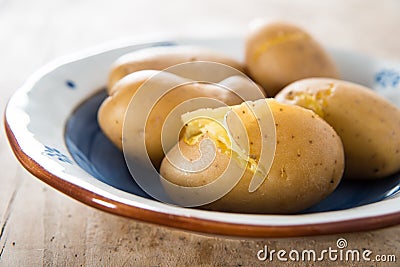 Cooked potatoes on hand painted terracotta dish Stock Photo