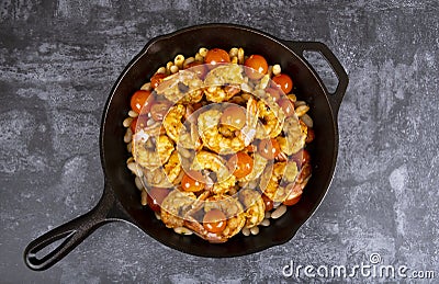 Cooked Spicy Garlicky Shrimps With Blistered Cherry Tomatoes and White Beans Stock Photo