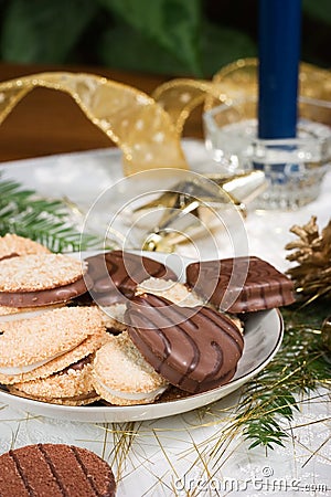Cookies, blue candle, fir branch, ornaments and pine cone on holiday napkin Stock Photo