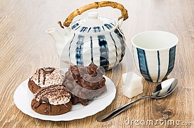 Cookies with chocolate and nuts, striped teapot, cup, lumpy sugar Stock Photo