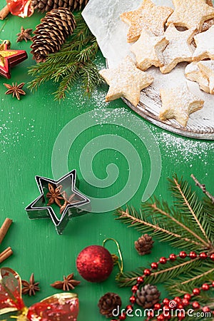 Cookies dusted with powdered sugar with Christmas decorations on green Stock Photo