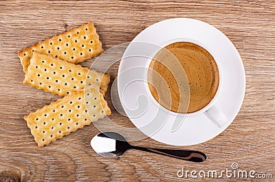 Cookies with filling, cup of coffee on saucer, spoon on table. Top view Stock Photo