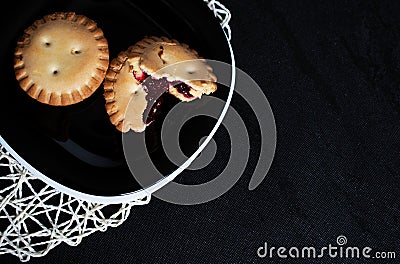 Cookies with jam on black plate on black backgroung Stock Photo