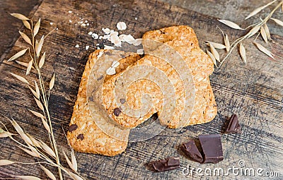 Cookies muesli made with raw organic cereals rice flour with chocolate on old wooden cutting Board. Stock Photo