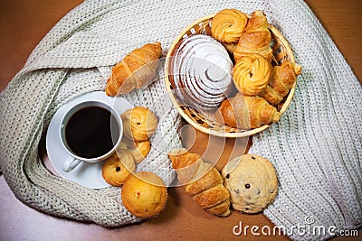 Cookies, pastries, coffee cup and gray scarf on wooden background Stock Photo