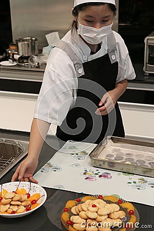 Beijing China - June 10, 2018: A female chef treats visitors with ready-made cookies, beautifully served on plates. Editorial Stock Photo