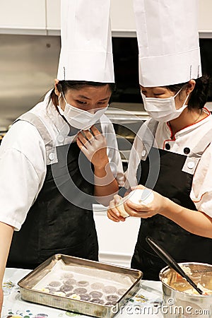 Beijing China - June 10, 2018:Two chefs lay out cookie dough on an iron baking tray. Editorial Stock Photo