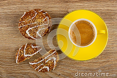 Cookies with sunflower seeds and sesame, broken cookie, coffee in cup on saucer on wooden table. Top view Stock Photo