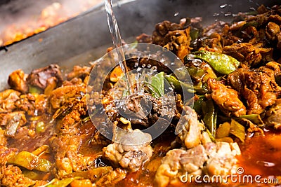 Cooking the authentic Valencian Spanish paella with chicken and rabbit. Stock Photo