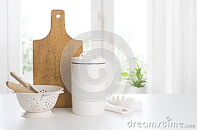 Cooking and baking utensils with cutboard on kitchen window background Stock Photo