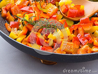 Cooking bell peppers with rosemary Stock Photo