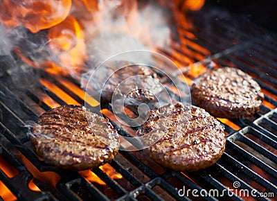 Cooking burgers on hot grill with flames Stock Photo