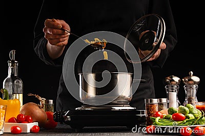 Cooking by the chef in the kitchen. Recipes and cooking, gastronomy. Culinary background. Italian pasta with ingredients Stock Photo