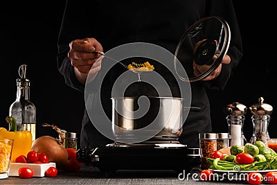 Cooking by the chef in the kitchen. Recipes and cooking, gastronomy. Culinary background. Italian pasta with ingredients Stock Photo